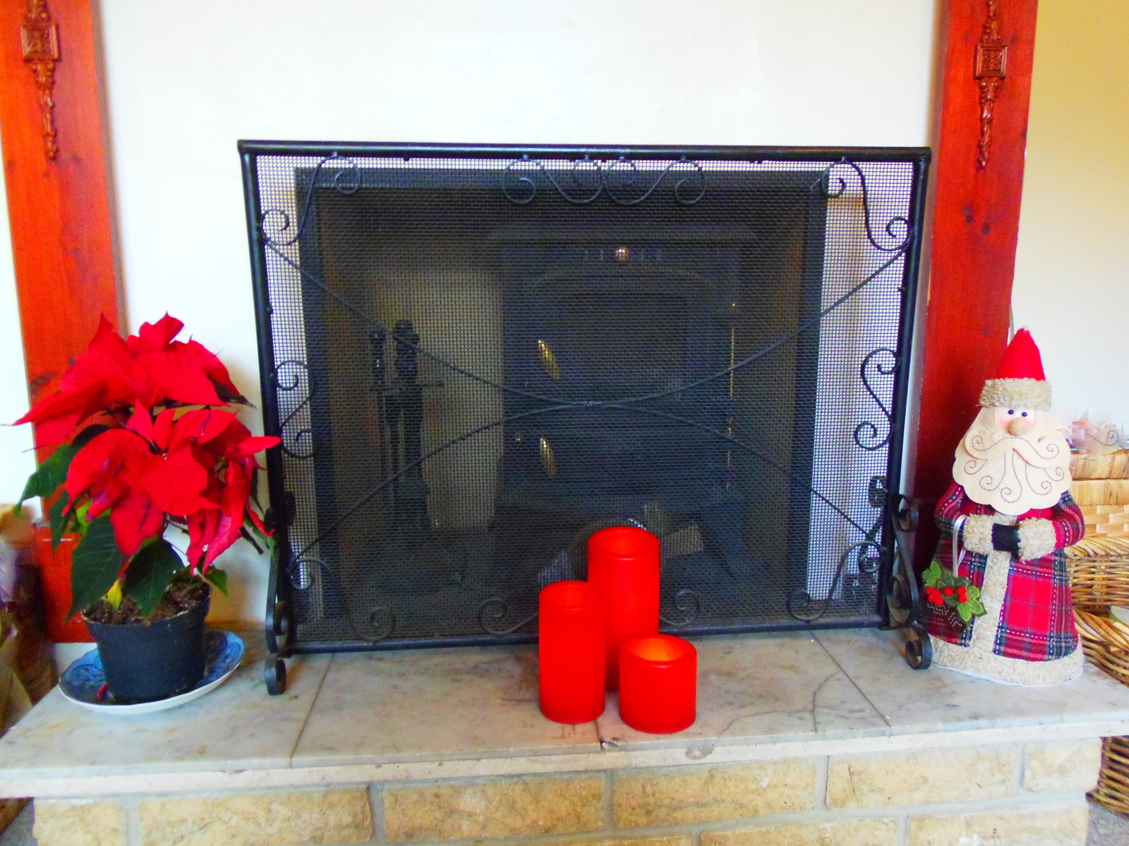 Red plant, candles and Santa on Fireplace